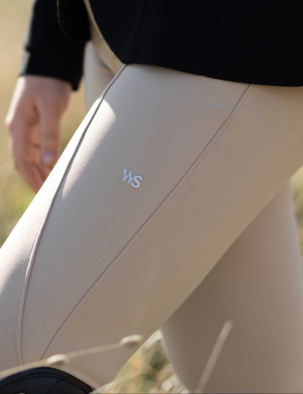 Close-up of Wilma Sport Classic Hybrid Breeches in Urban Sand showing WS logo and seam detail.