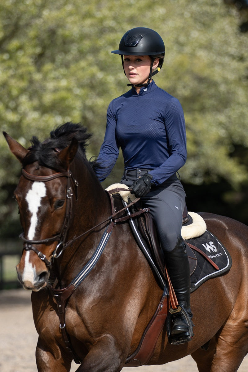Rider and horse, dressed in Wilma Sport Featherlight Training Shirt in Urban Navy and Classic Hybrid Breeches in Slate Grey.